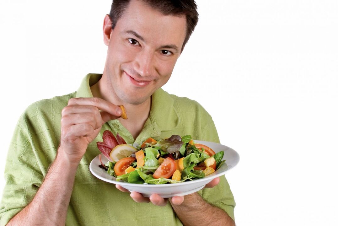 home comendo ensalada de verduras para potenciar
